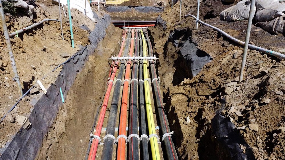 several runs of YJV cables laid in the ground and supported by spacers, ready to be buried