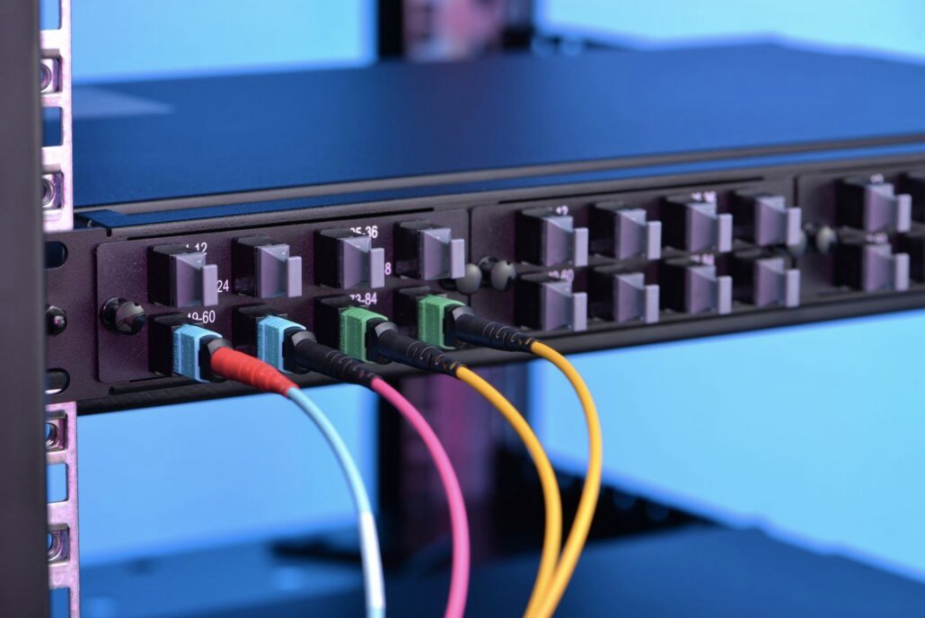 several color-coded MPO/MTP patch cords connected to a networking panel
