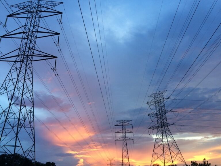 electrical pylons with Power Cables stretching across a twilight scene.