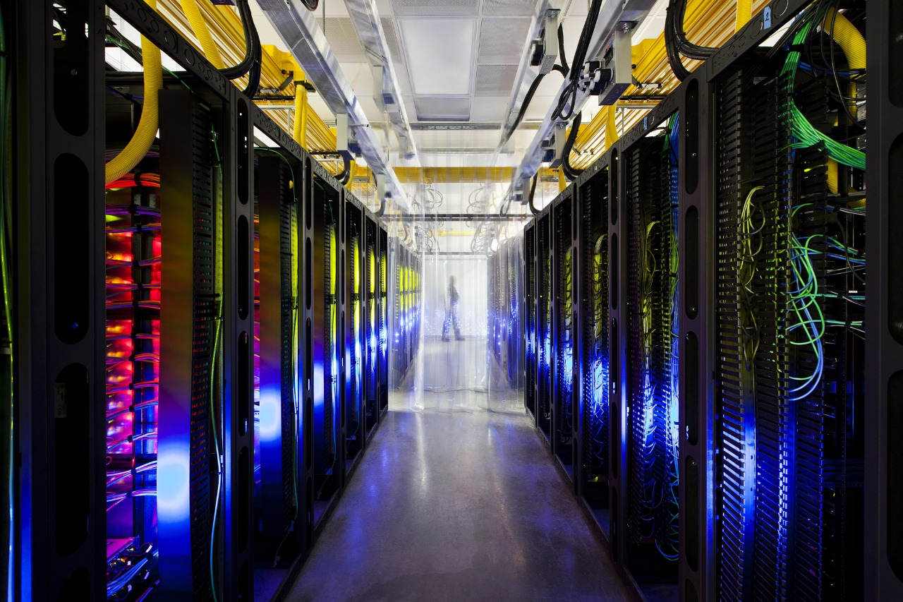 Aisle of servers with blue and red lights in a data center, highlighting data center solutions.