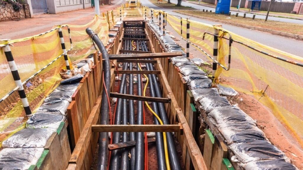 Underground power cables being installed in a trench alongside a road.