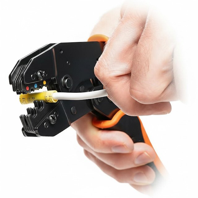 A person holding an electrical cable crimping tool with a yellow connector and white cable
